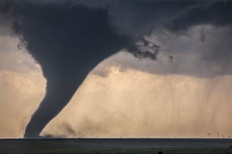 a tornado next to wind turbines 