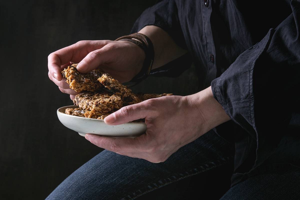 Three cereal bars sit on a plate.