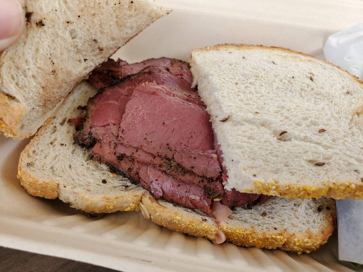 A pastrami sandwich is served at a restaurant.