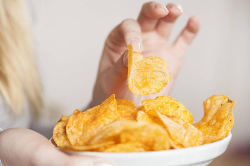 Two potato chips lie on a grey table.