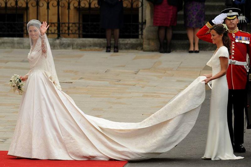 Kate Middleton (L) waves as she arrives with her sister, the Maid of Honour Philippa Middleton at the West Door of Westminster Abbey