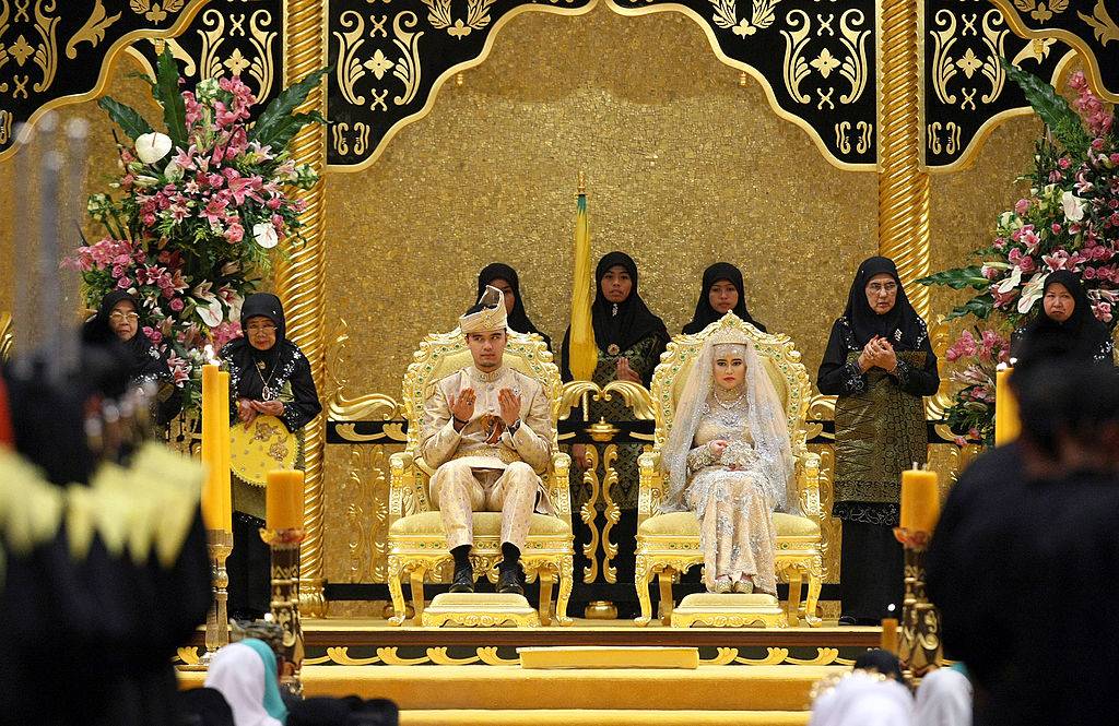 The Royal couple Princess Hajah Hafizah Sururul Bolkiah and her groom Pengiran Haji Muhammad Ruzaini (L) pray at the end of the sitting-in-state on royal dais ceremony