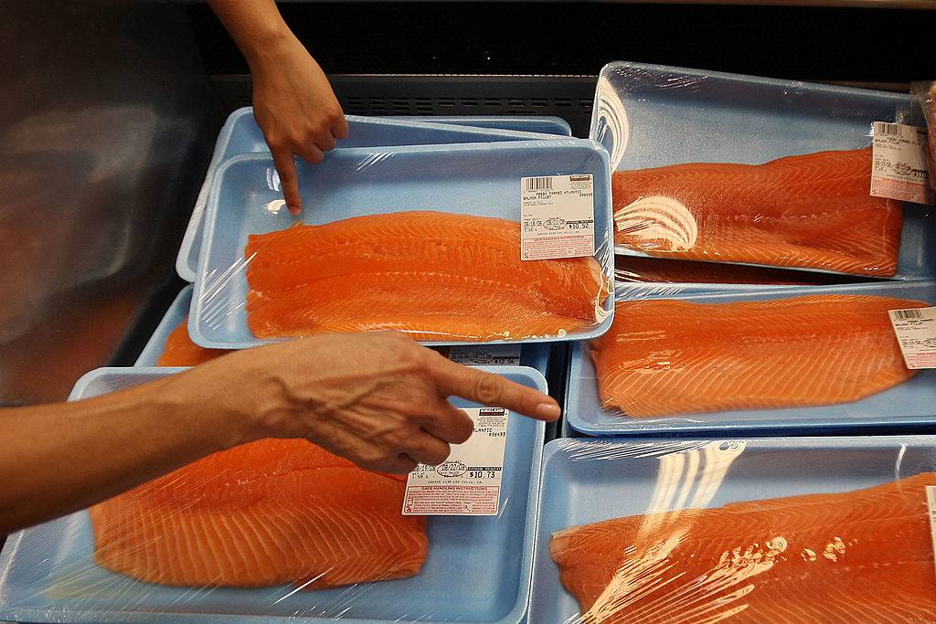 people picking out salmon at a grocery store