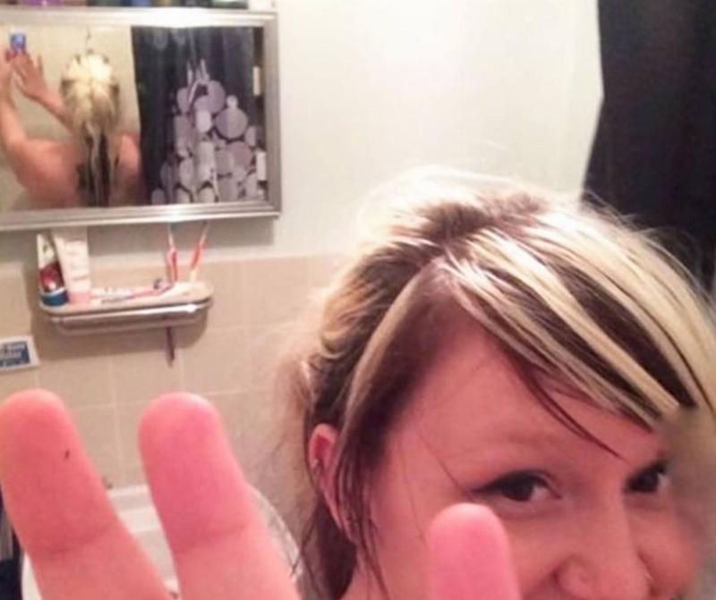 woman pretending she doesn't want her photo taken can be seen doing it herself in mirror behind her