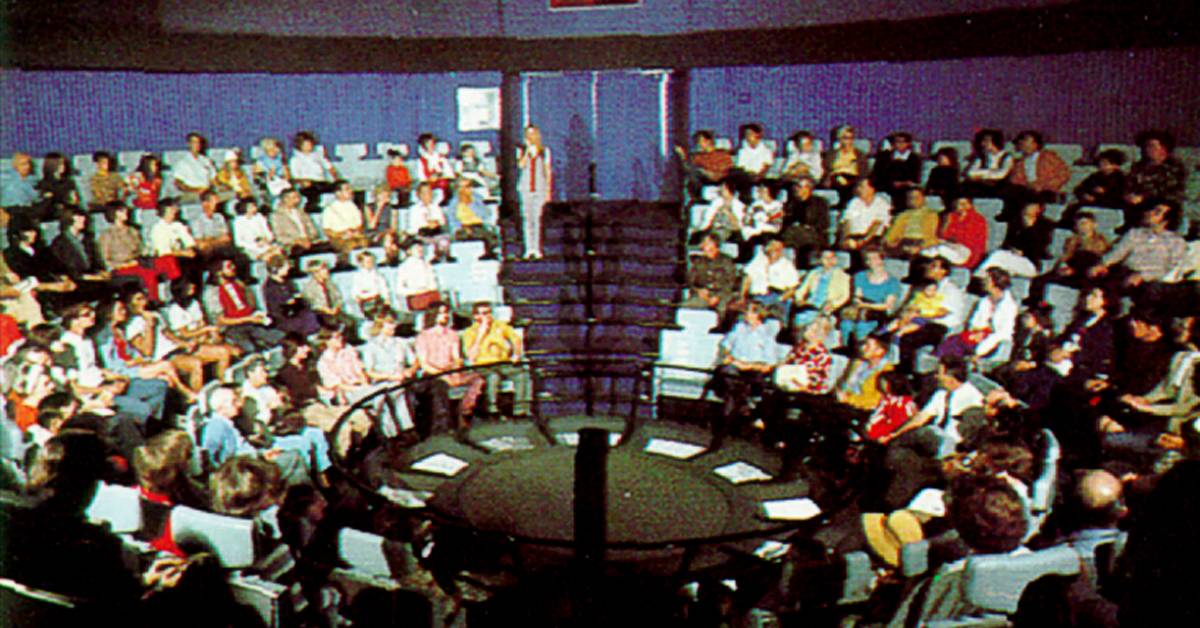 people sitting in a round theater on flight to the moon at disneyland