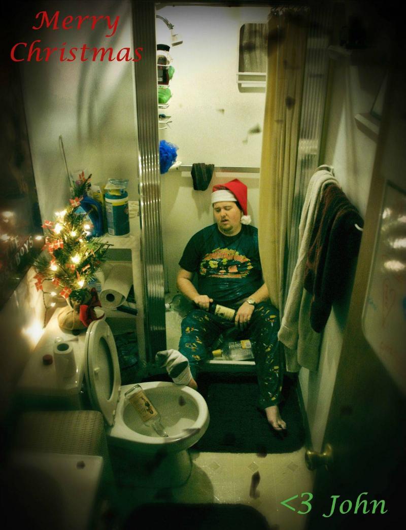 man in santa hat passed out in bathroom with liquor bottles everywhere and script: Merry Christmas <3 John