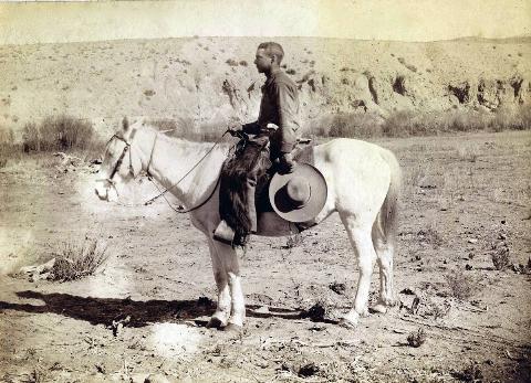 A southwestern cowboy sits on a horse in 1878.