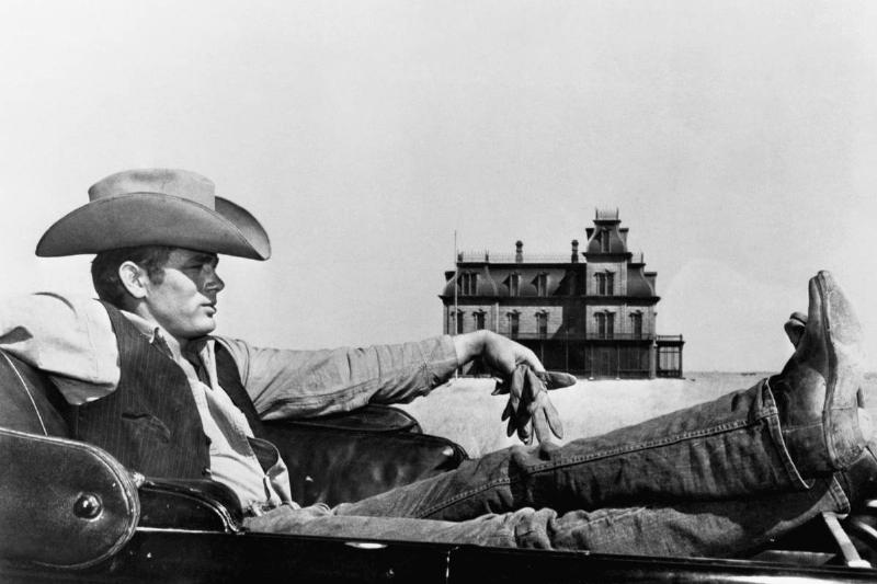 American actor James Dean poses for a movie wearing a cowboy hat.