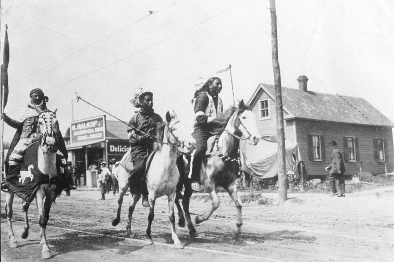 Native Americans race horses in the late 19th century.