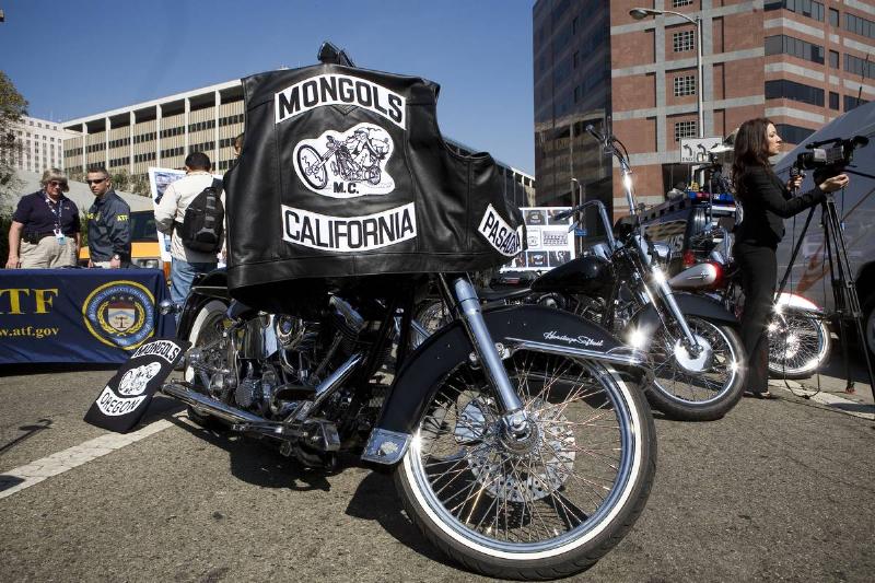 A Mongols motorcycle club jacket is draped over a bike.