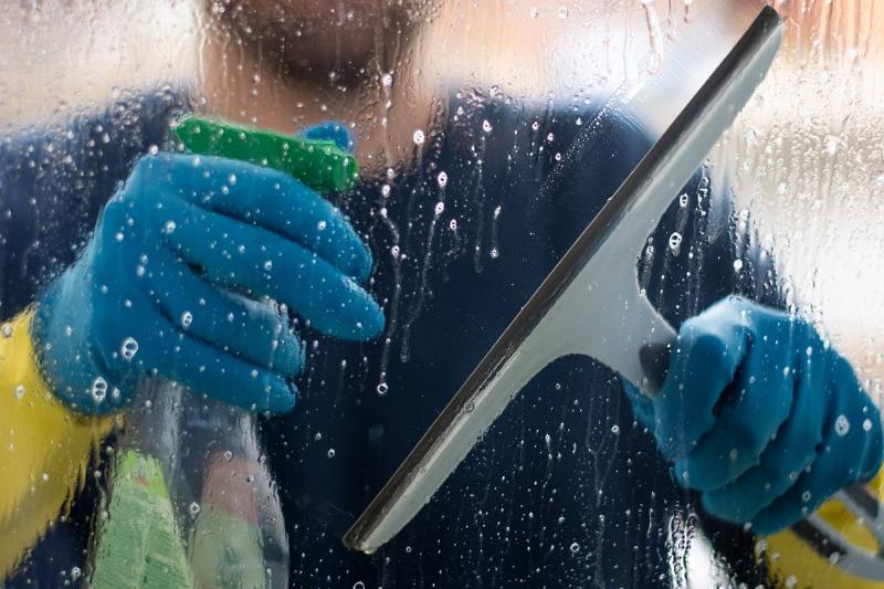someone washing window from outside with squeegee