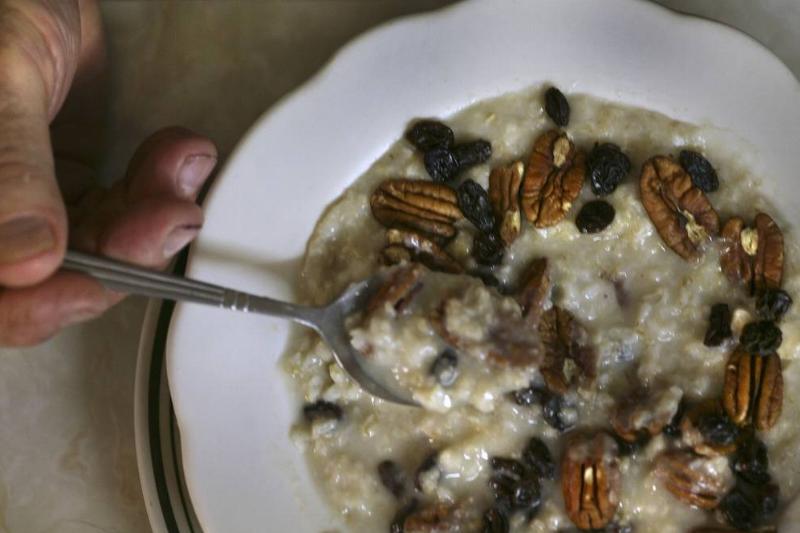 A person digs a spoon into oatmeal.