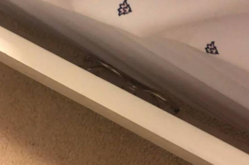 pair of glasses stuck between edge of bedframe and mattress
