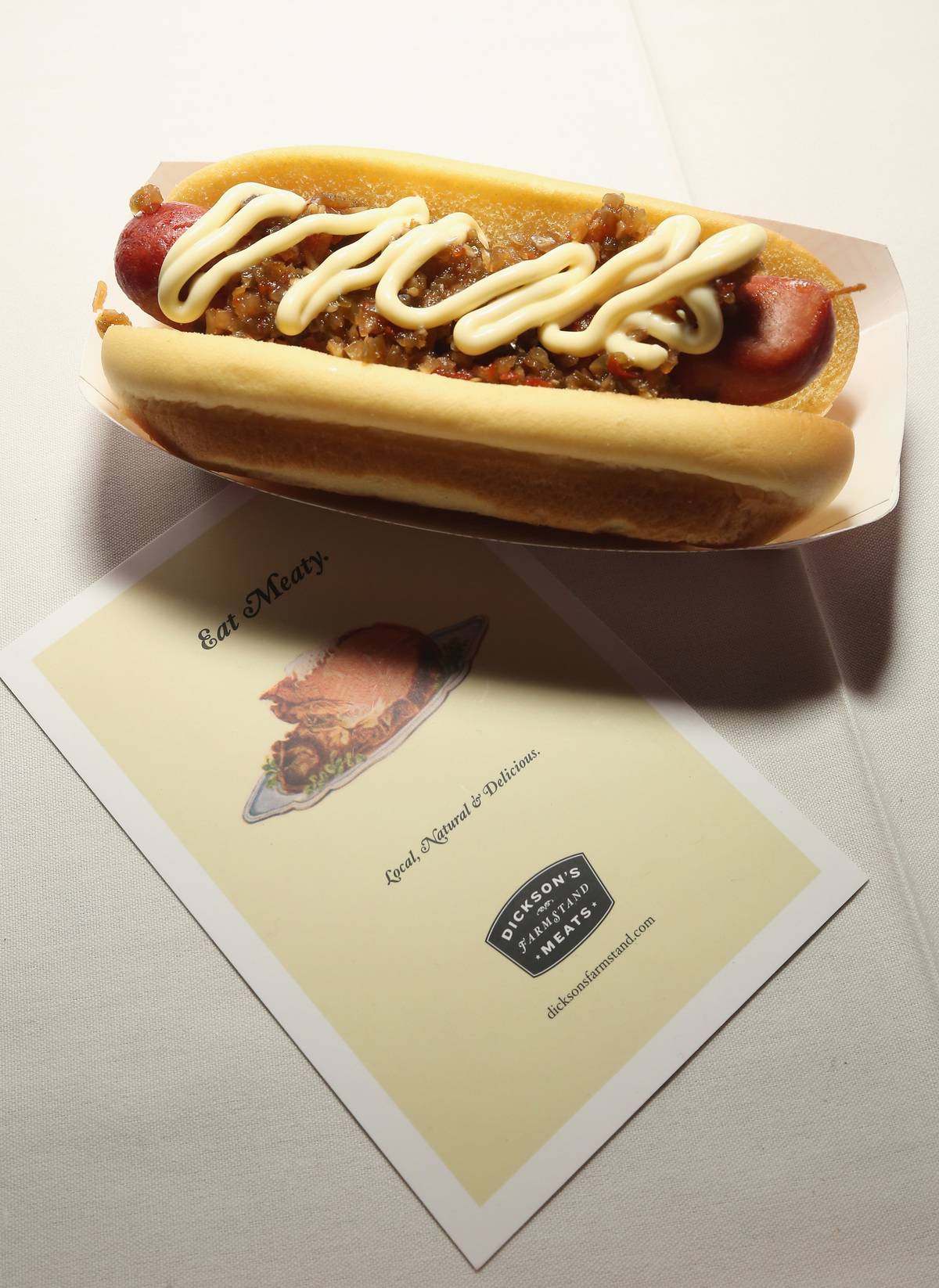 A hot dog is displayed with a pamphlet during a food competition.