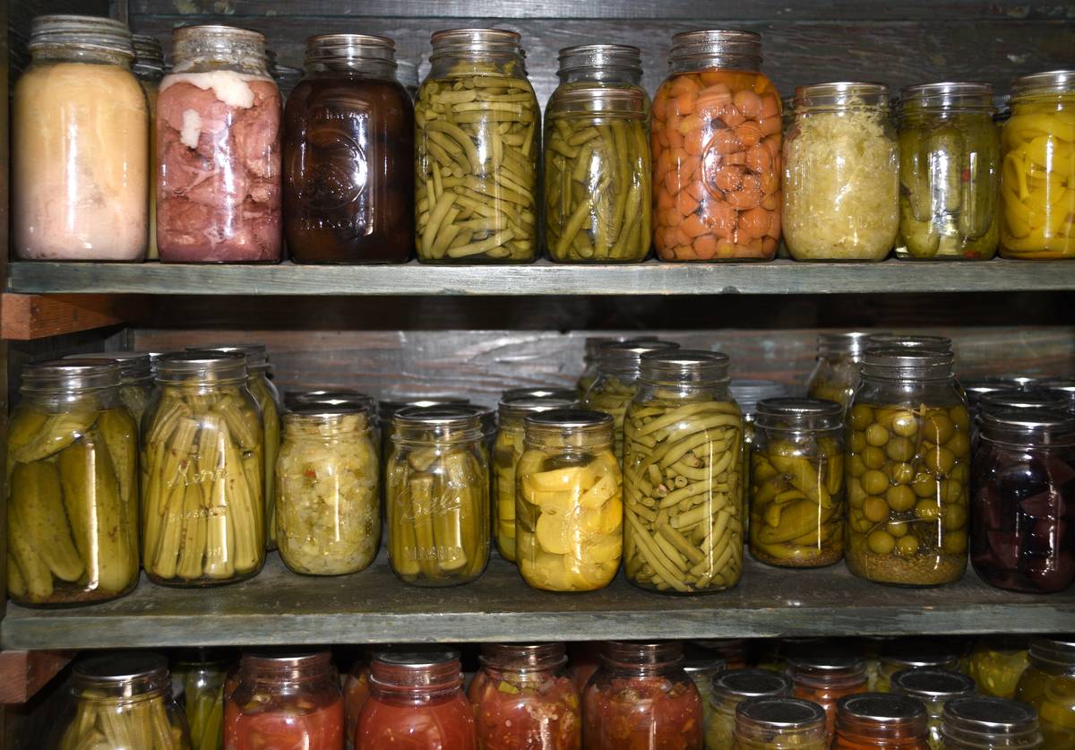 A variety of preserved vegetables are seen in jars.