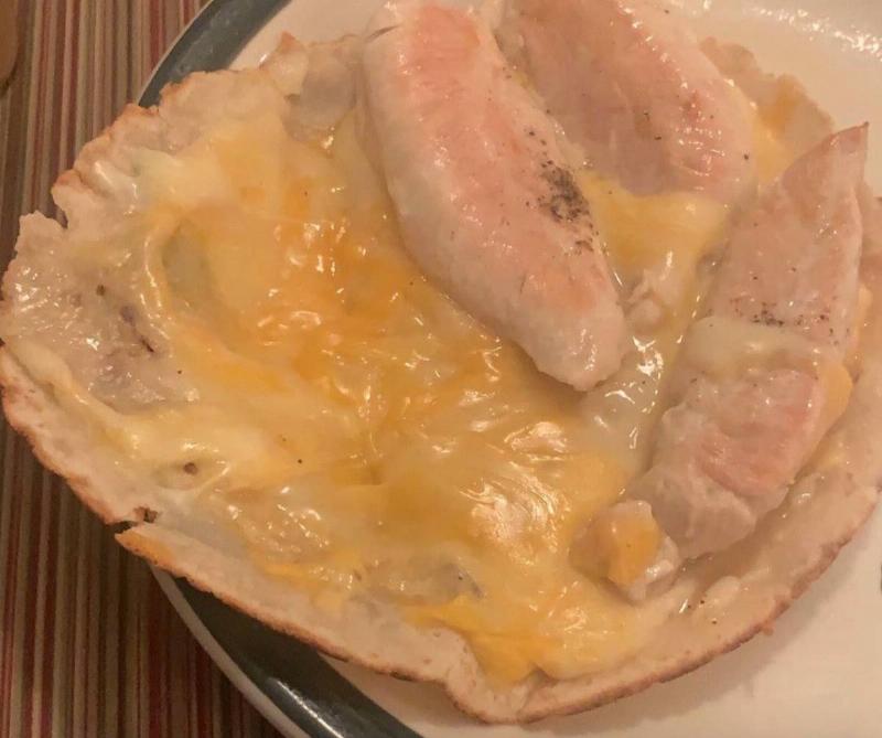 a tortilla with melted cheese and sort of cooked chicken on it 