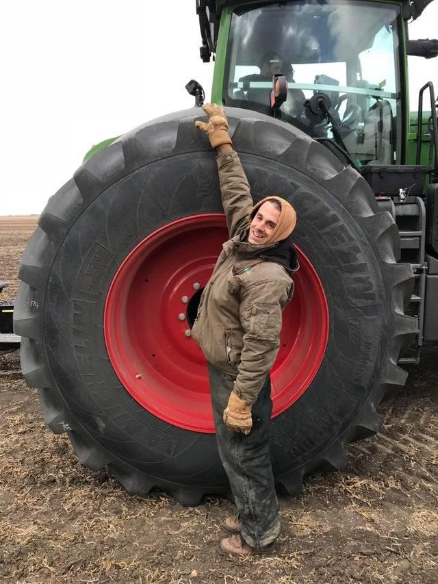 man standing next to Fendt 1046 tractor rear tire