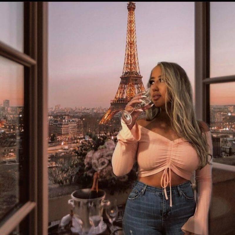 woman 'posing' in front of extremely fake looking paris background