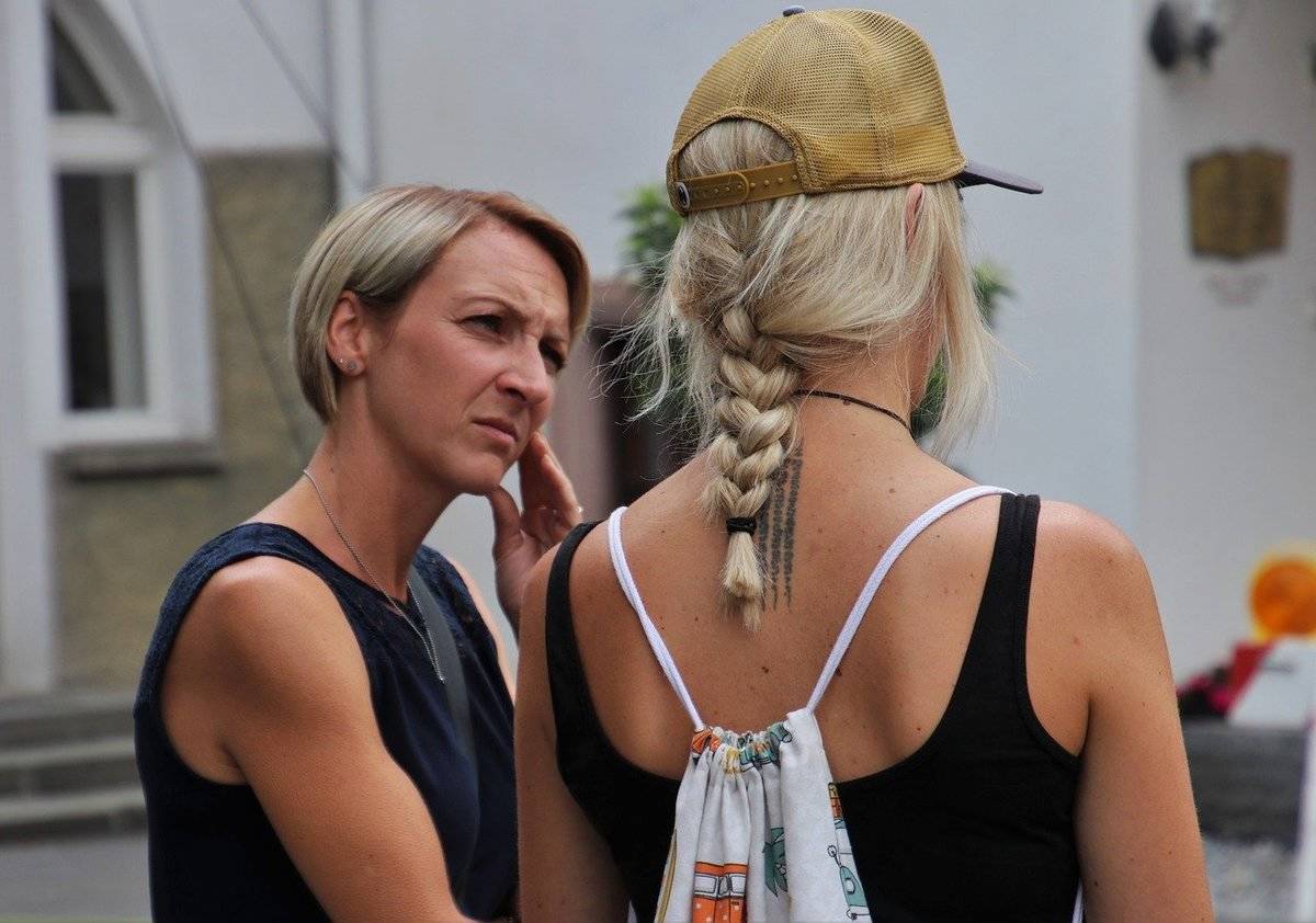 A woman appears concerned and confused while speaking to another woman.