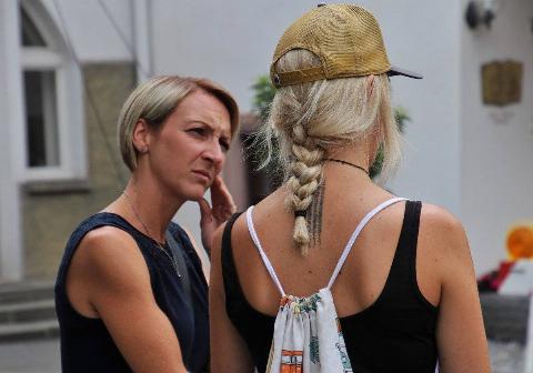 A woman appears concerned and confused while speaking to another woman.