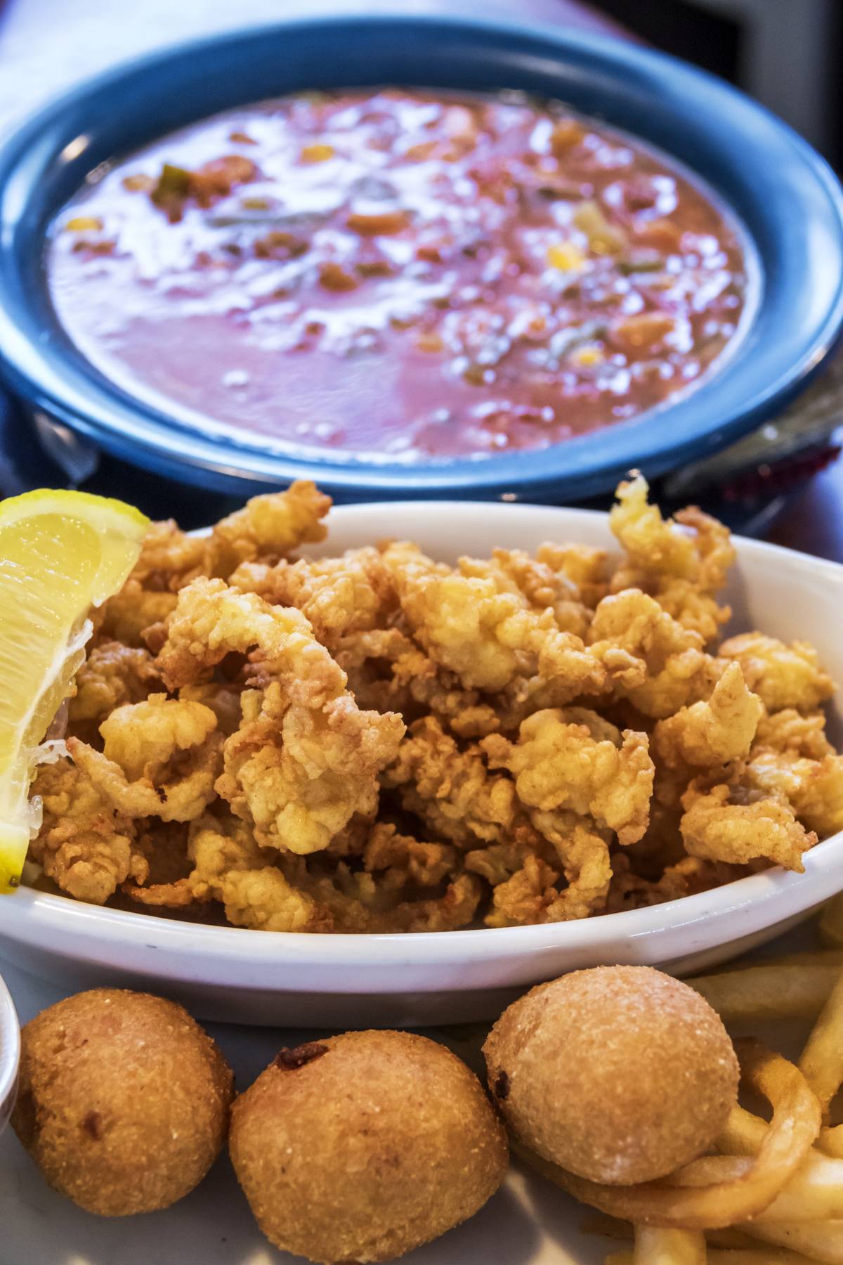 Fried clams and hush puppies are portrayed next to sauce in a North Carolina restaurant.