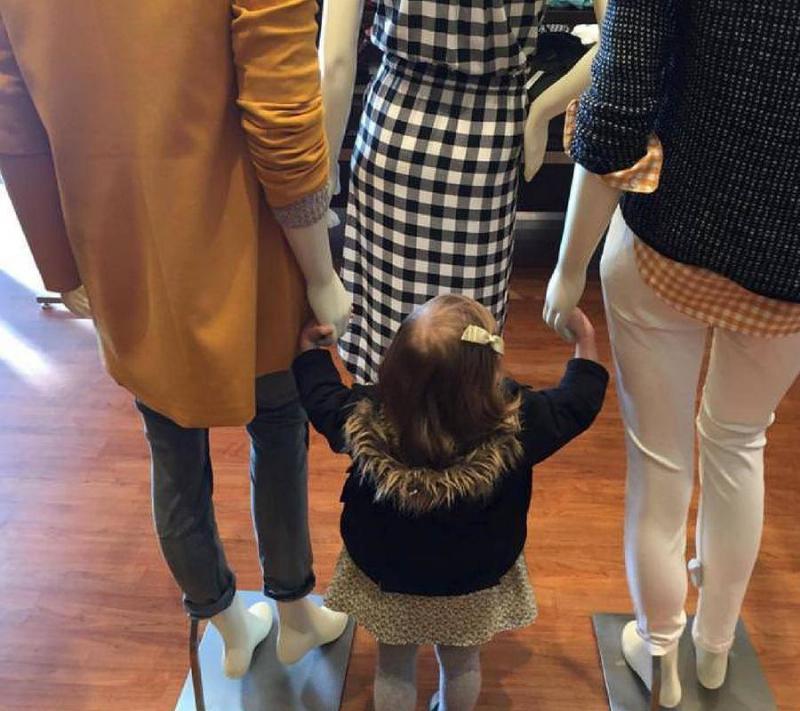 child holding hands of mannequin in store