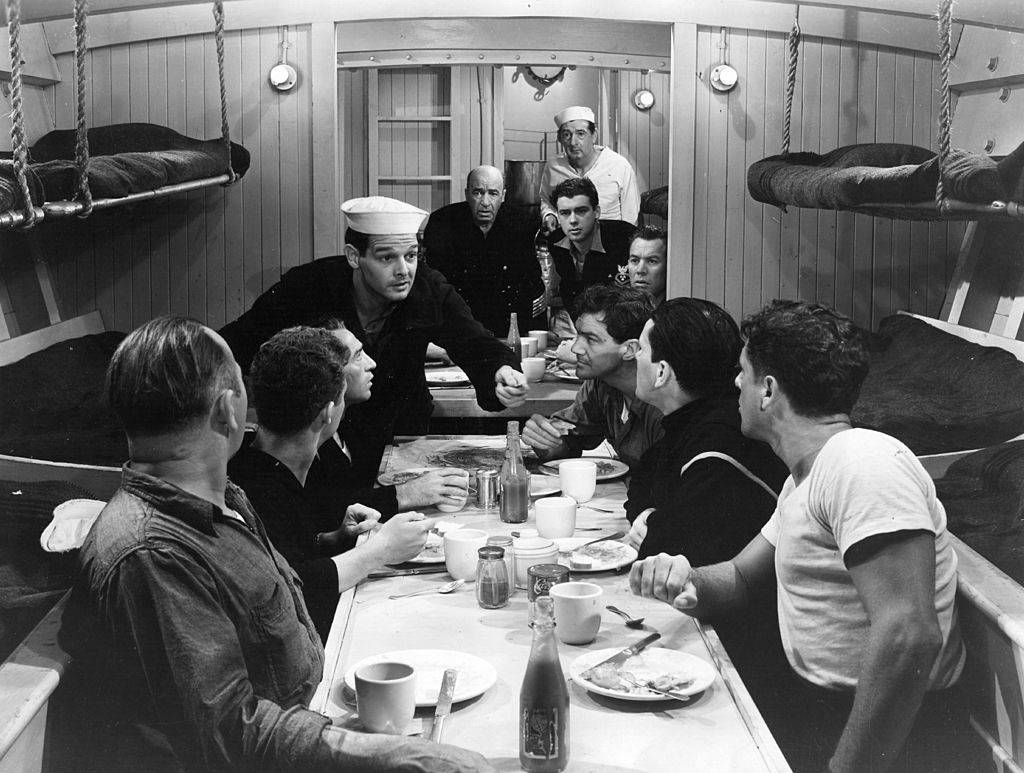 black and white photo of soldiers eating on a submarine