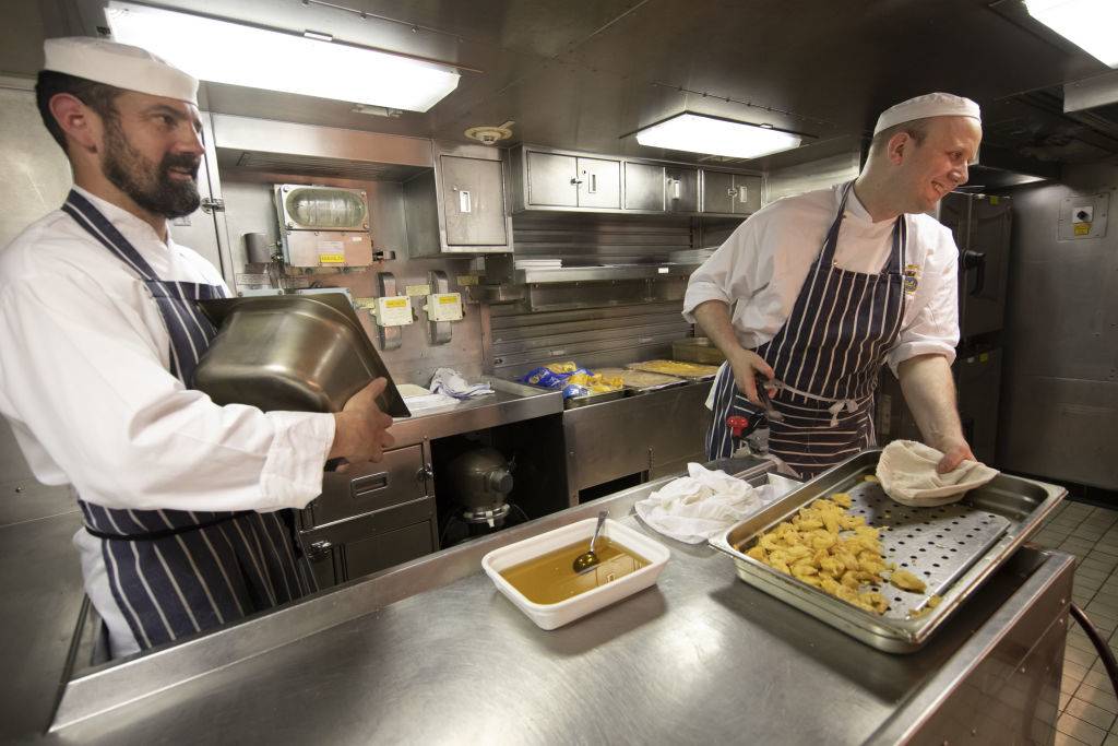 chefs preparing food on a submarine kitchen