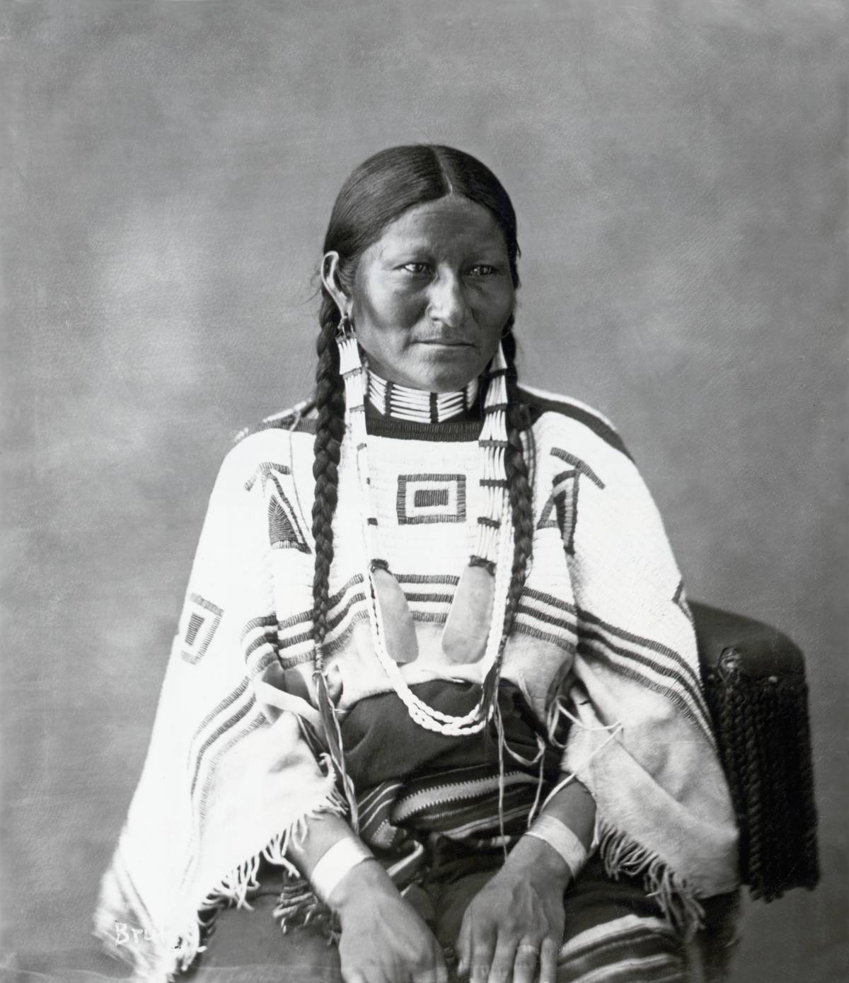 Brule-Teton Sioux woman wears traditional clothing in this photo.