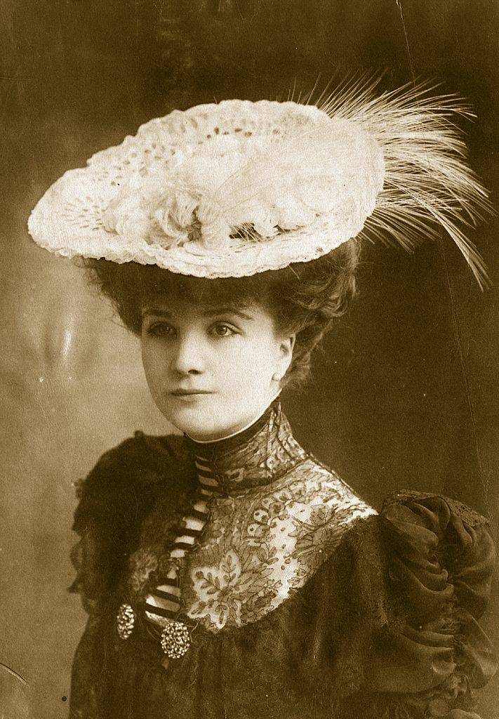 An Edwardian white lace hat with feather trimming