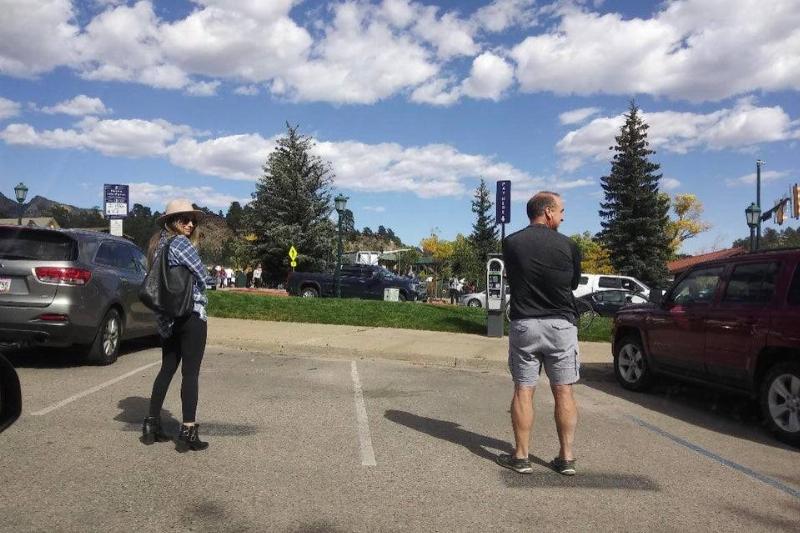 Two people standing in parking spots