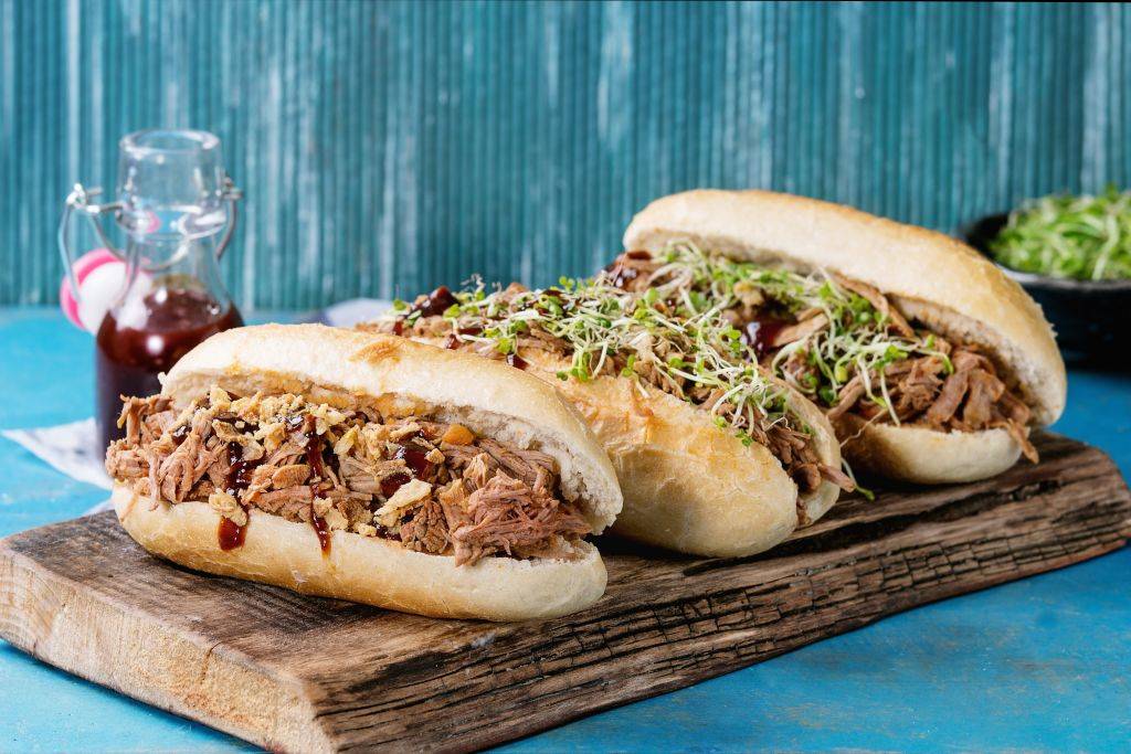 pulled pork sandwiches with meat, fried onion, green sprouts and bbq ketchup