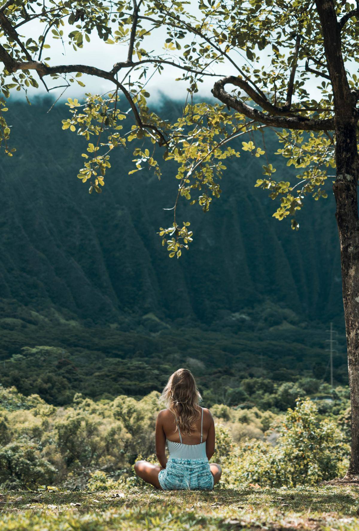 Woman sitting alone outside looking at forest 