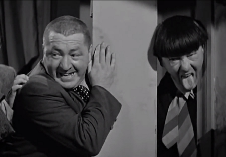 Curly Howard on set of Three Stooges laughing, Moe sticks out tongue from behind pillar