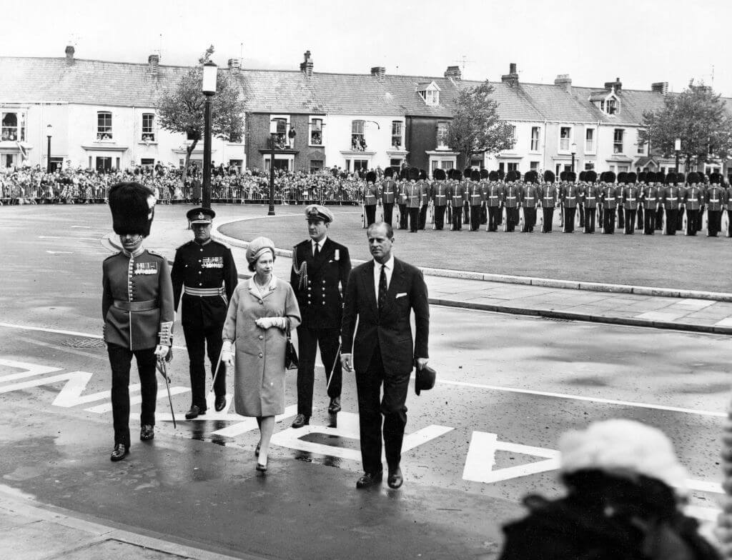 Queen Elizabeth walks with Prince Philip in step behind her