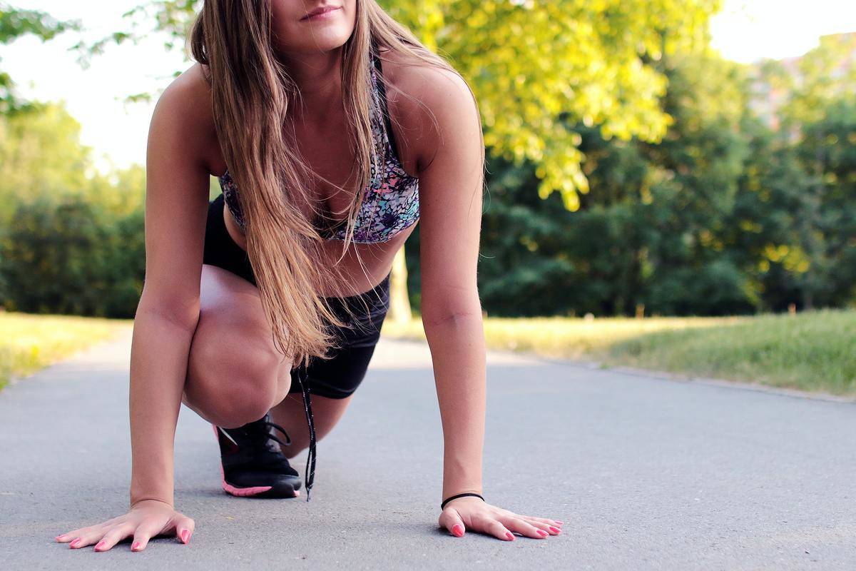 Girl wearing sports bra, sneakers, and shorts to go running