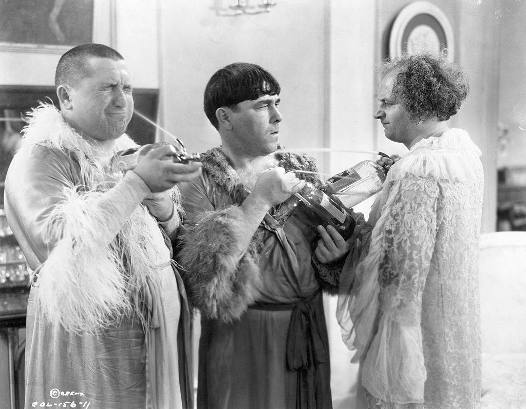 Three Stooges dressed in women's sleeping gowns