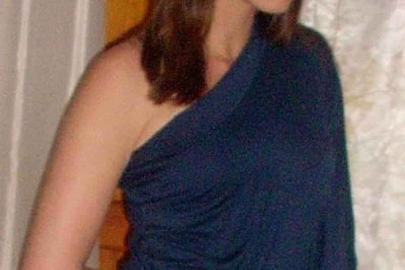 woman in a blue shirt with an asymmetrical neckline