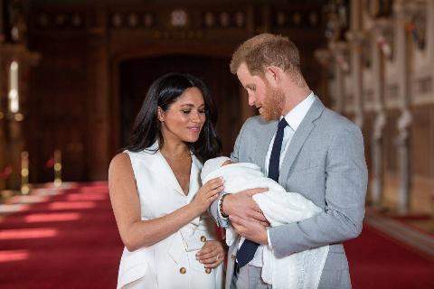 Britain's Prince Harry, Duke of Sussex (R), and his wife Meghan, Duchess of Sussex, pose for a photo with their newborn baby son, Archie Harrison Mountbatten-Windsor, in St George's Hall at Windsor Castle in Windsor, west of London on May 8, 2019
