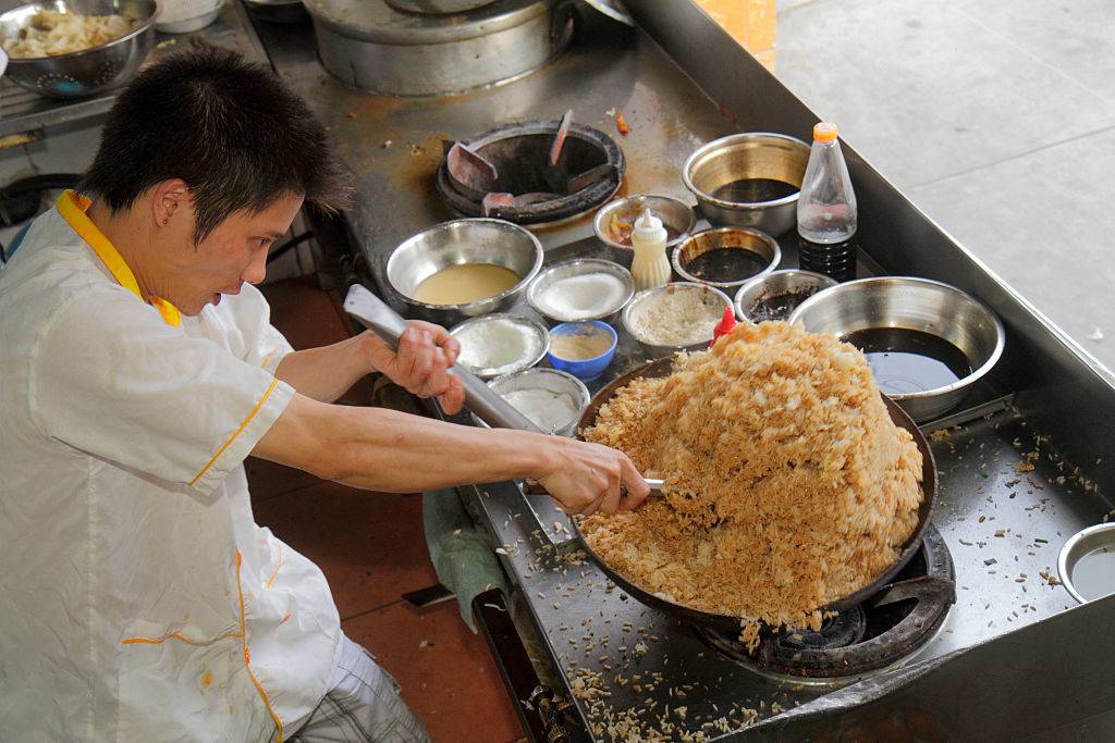 chef cooking brown rice on a wok burner
