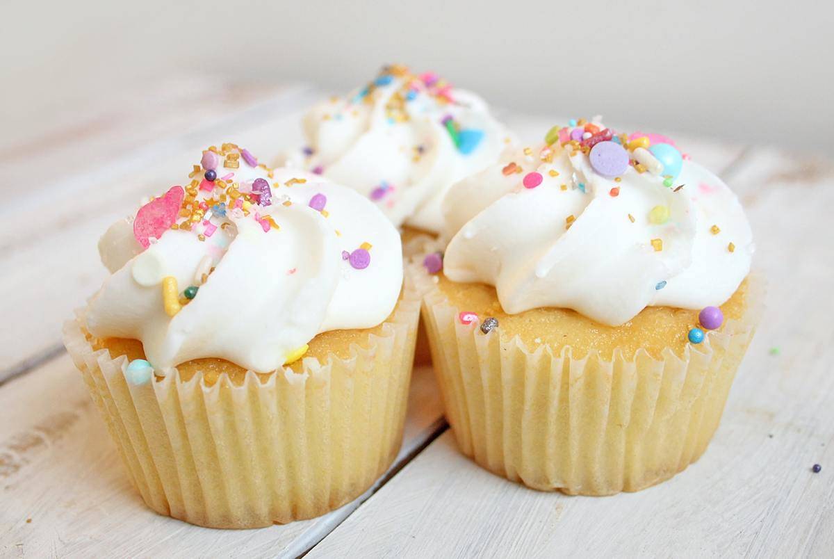 cupcakes with vanilla frosting and colored sprinkles