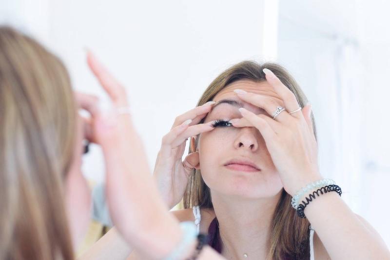 girl-attaching-fake-eyelashes-in-front-of-a-bathro-2022-11-14-05-56-46-utc