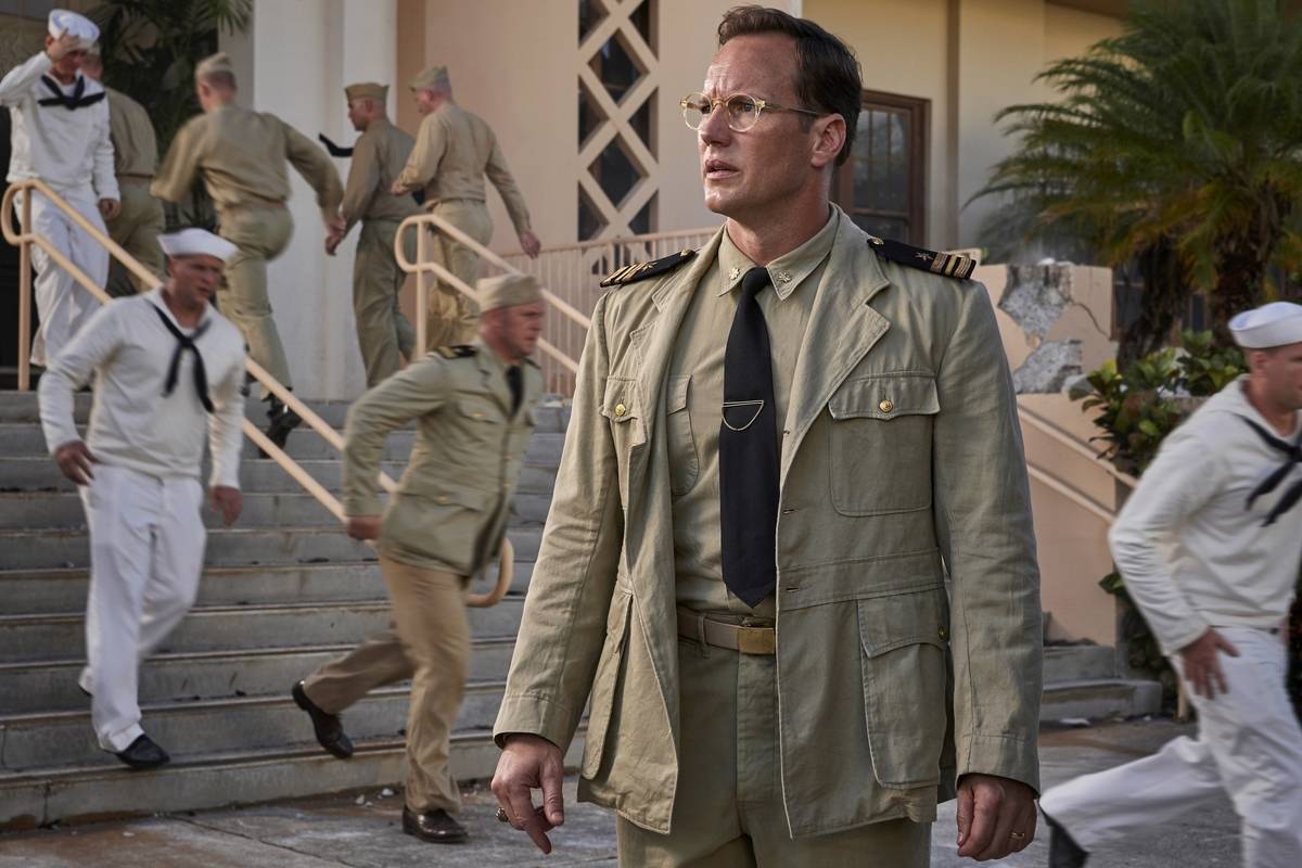 Patrick Wilson looking shocked as sailors run behind him in Midway