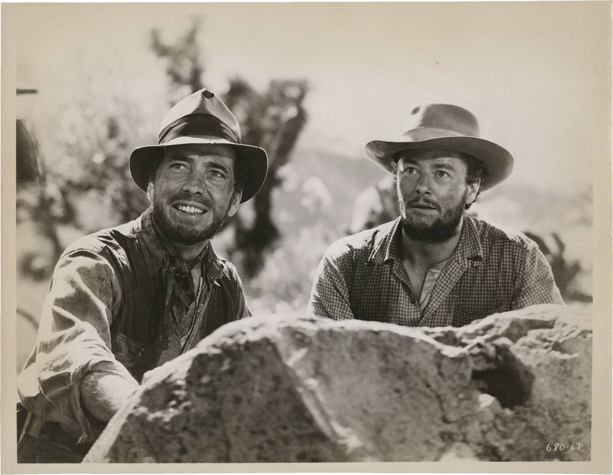 Humphrey Bogart and Tim Holt smiling in The Treasure of the Sierra Madre