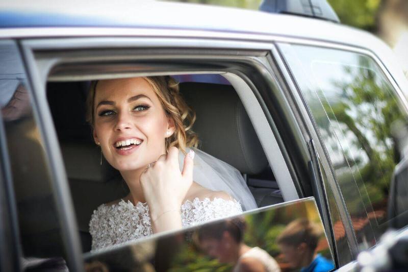 bride smiling through car's open window