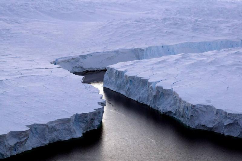 This file picture shows an enormous iceberg (R) breaking off the Knox Coast in the Australian Antarctic Territory on January 11, 2008.