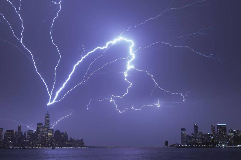 Lightning bolts strike One World Trade Center in New York City as it fans out over the Hudson River and Jersey City, New Jersey during a thunderstorm on April 1, 2023, as seen from Hoboken, New Jersey.