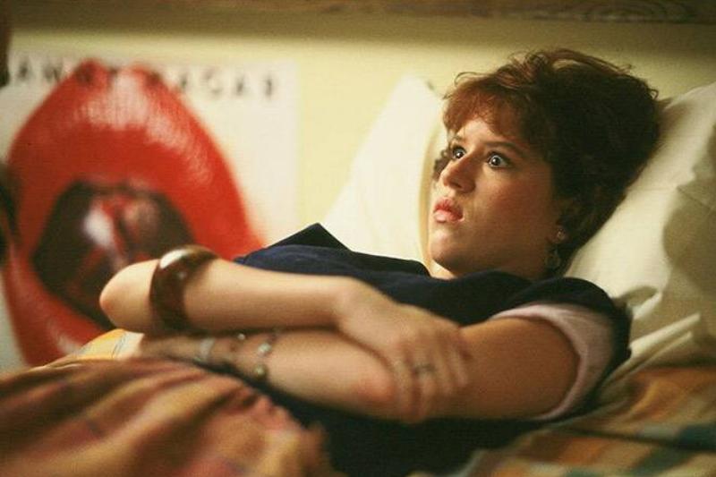 Molly Ringwald laying in bed as Samantha in Sixteen Candles