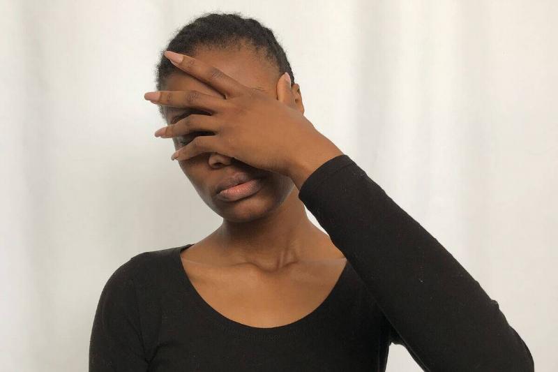 Woman holding her face in her hand