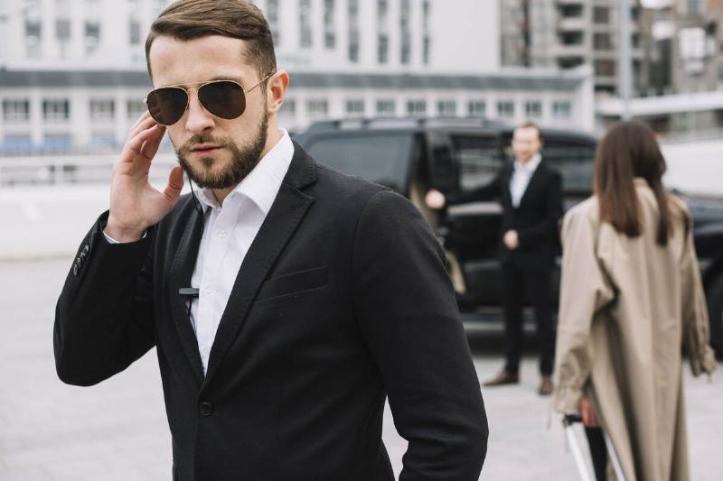man in security detail touching earpiece
